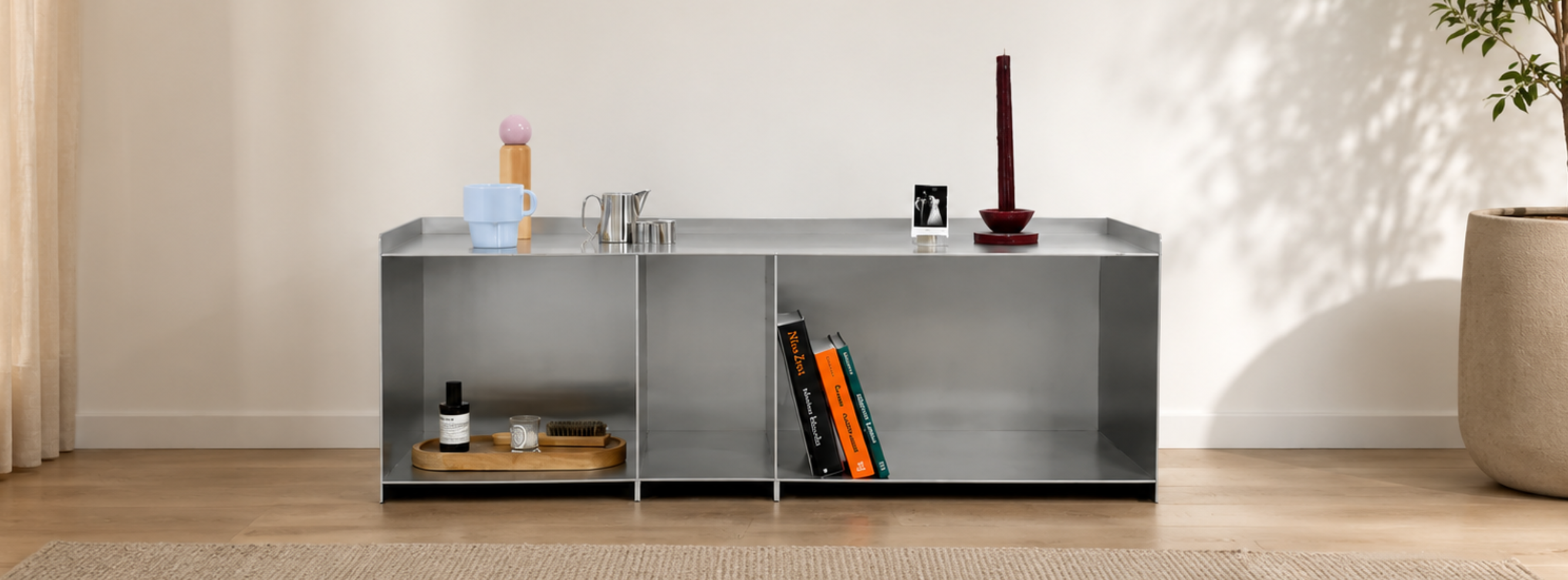 Custom aluminum TV stand supporting a large flatscreen television in a modern minimalist living room setting.