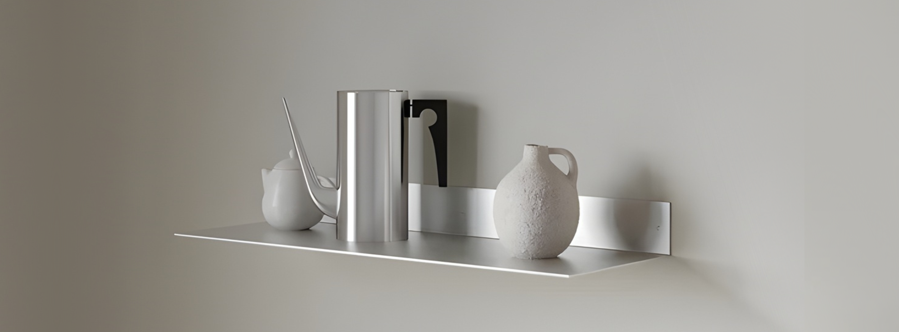 Modern silver aluminum floating shelf mounted on a minimalist living room wall.