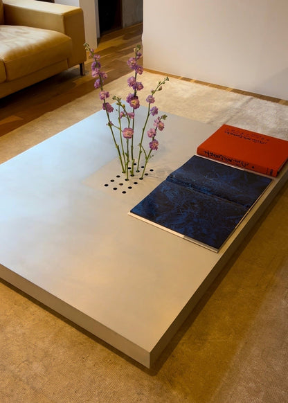 Low metal table. Hole with cover